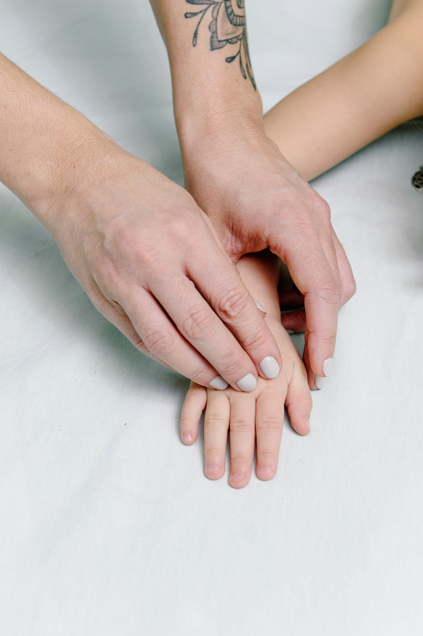 Main d'adulte et main d'enfant reliées pendant l'atelier parent-enfant